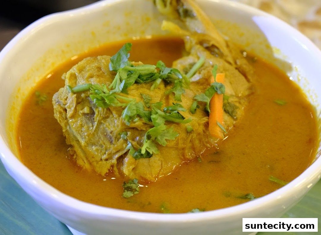 A close-up shot of a delicious fish head curry served in a white bowl.