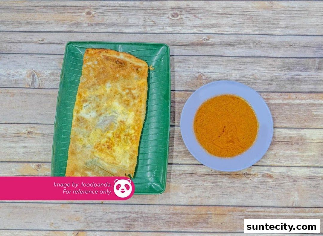 A delicious prata served with curry on a wooden table.