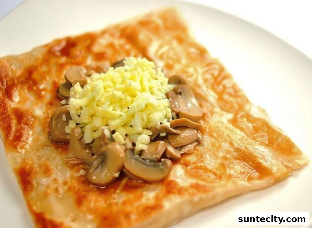 A close-up shot of a prata dish topped with mushrooms and grated cheese.