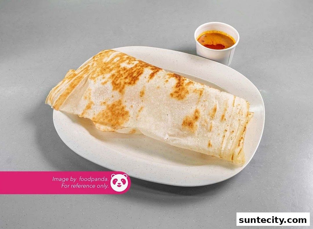 A delicious prata with curry served on a white plate.