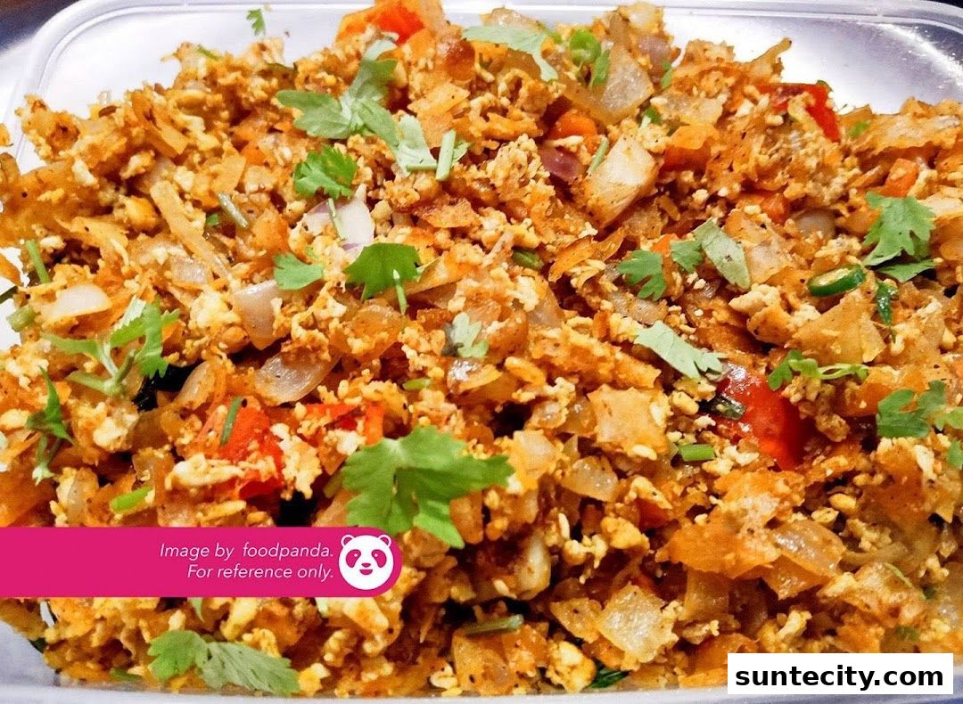 A close-up of a delicious-looking prata scramble with onions, tomatoes, and cilantro.