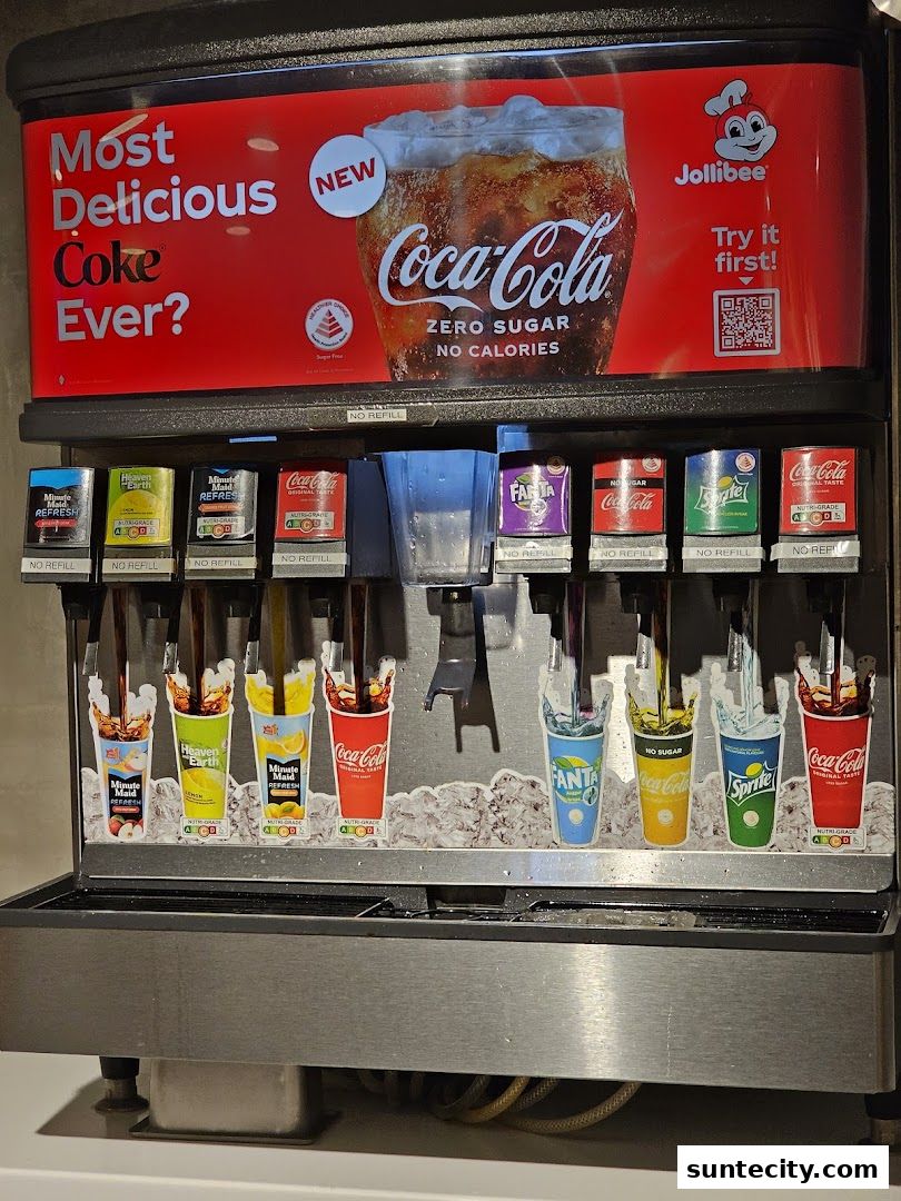 A Jollibee beverage dispenser featuring Coca-Cola Zero Sugar and various other soft drink options.