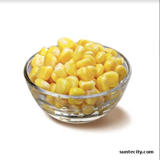 A clear glass bowl filled with bright yellow corn kernels on a white background.