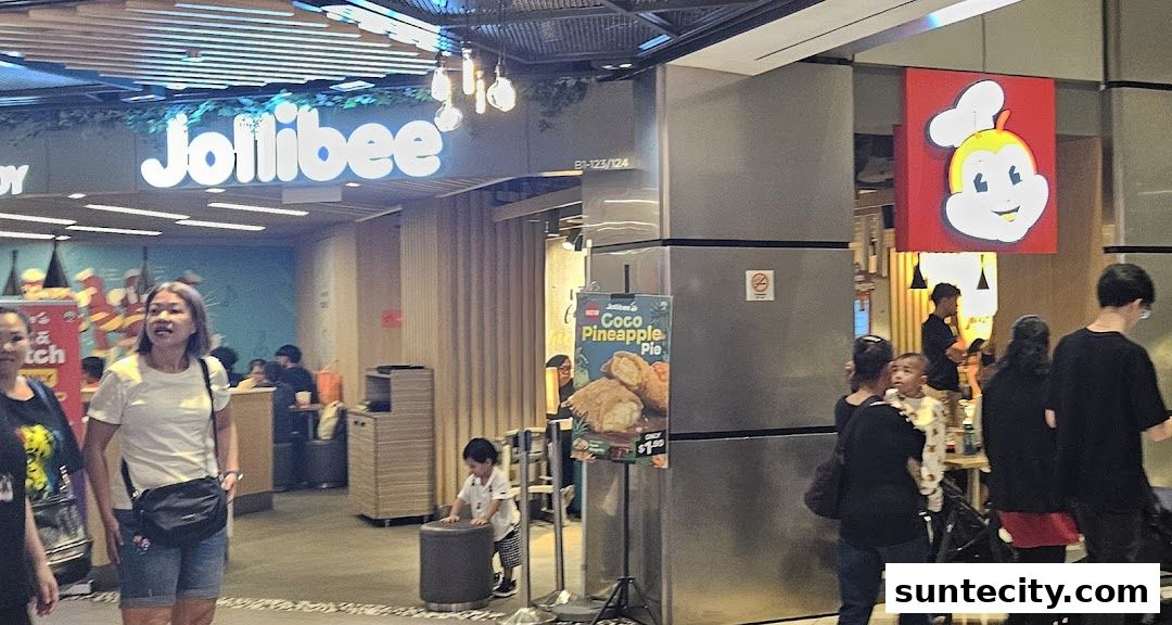 The Jollibee Suntec City storefront with customers and a promotional sign for Coco Pineapple Pie.
