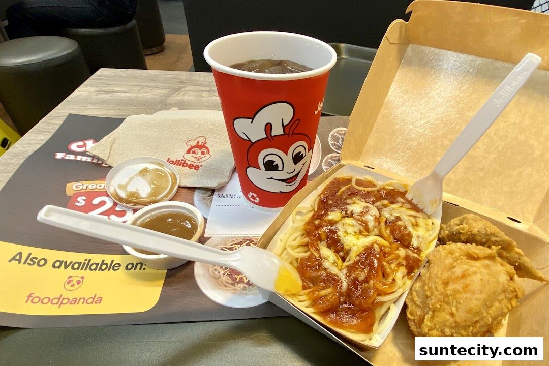 A Jollibee meal featuring spaghetti, fried chicken, a drink, and dipping sauces.
