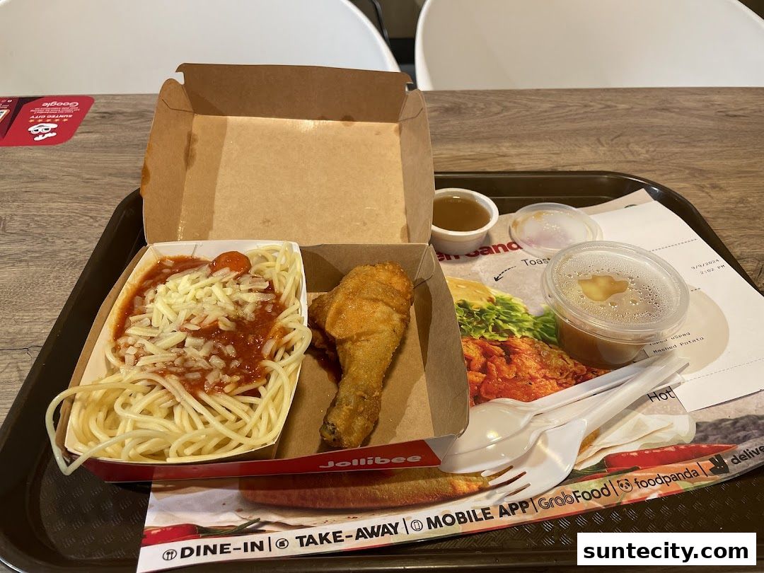 A Jollibee meal featuring spaghetti, fried chicken, and mashed potatoes on a tray.