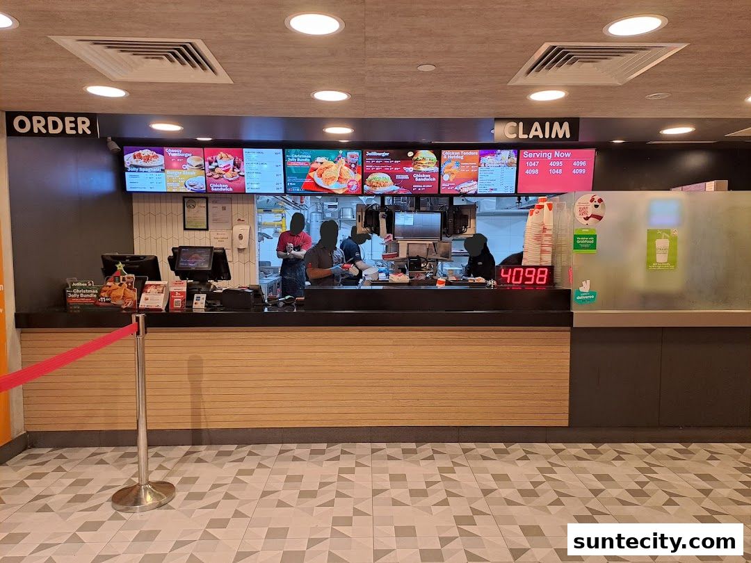 Jollibee counter with digital menus displaying food items and serving numbers.