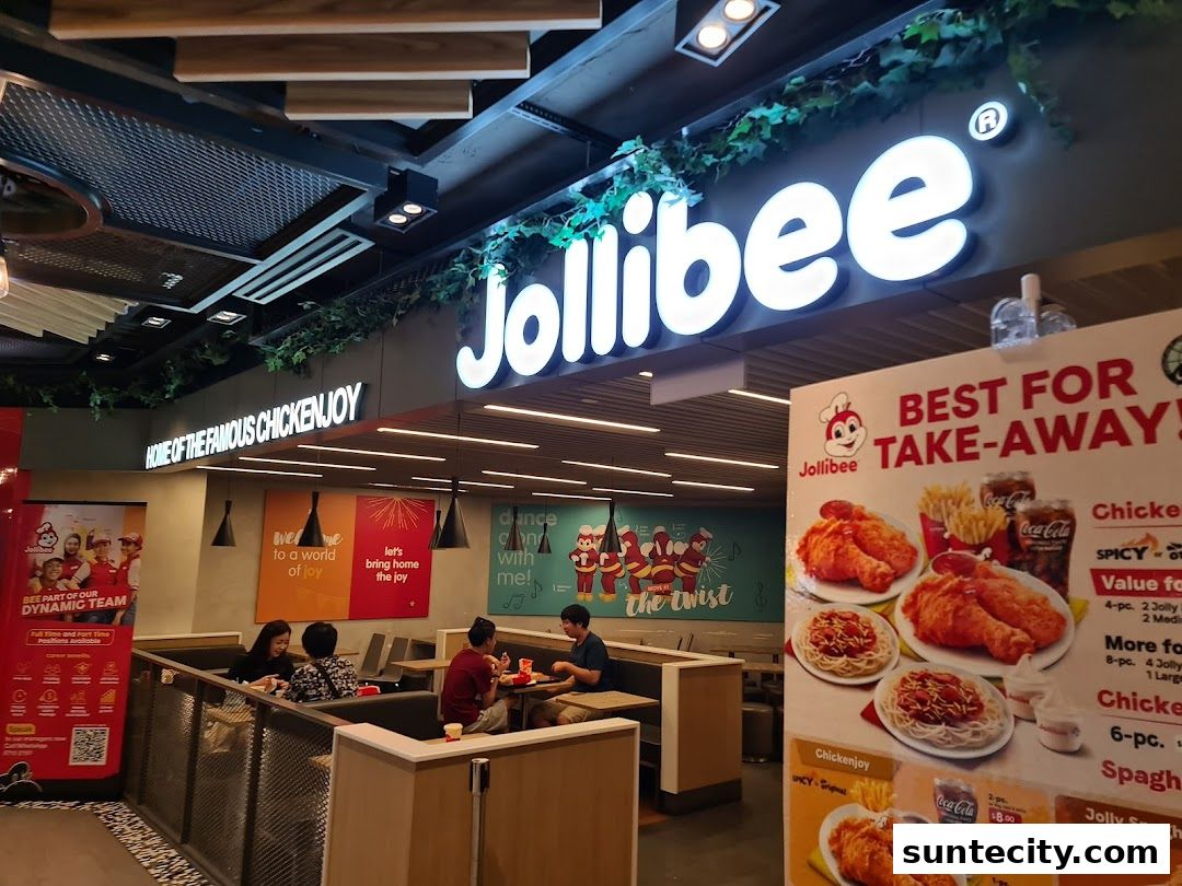 Jollibee restaurant interior with customers dining and a prominent takeaway menu display.