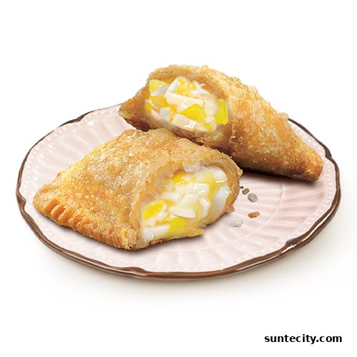 Two golden-brown fried pies filled with creamy white and yellow filling on a pink plate.