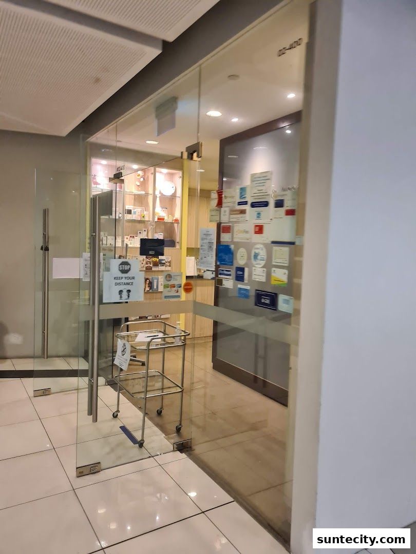 The entrance to K N Chin Associates, a shop with glass doors and displays inside.