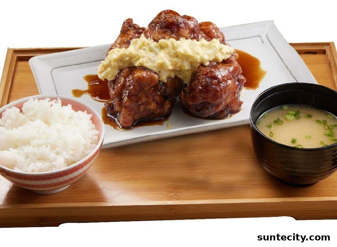A delicious Japanese meal featuring fried chicken, rice, and miso soup.