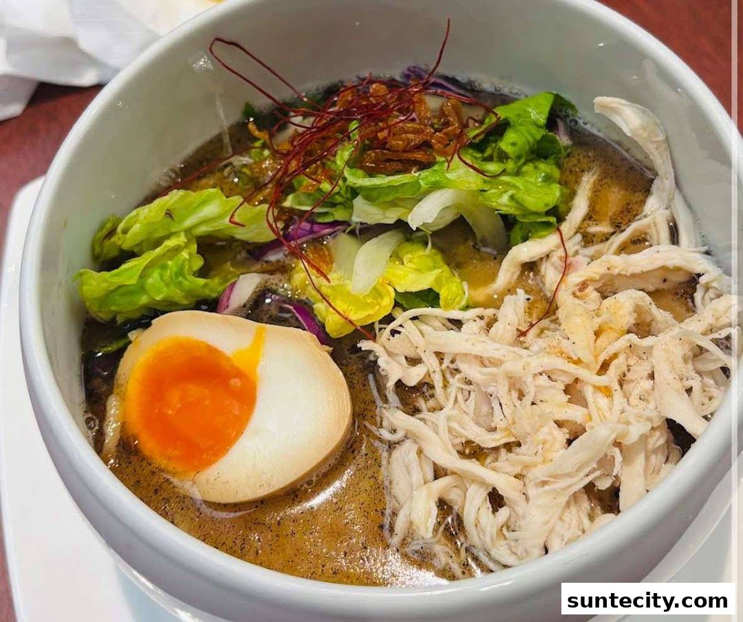 A close-up shot of a delicious bowl of ramen with shredded chicken and a soft-boiled egg.