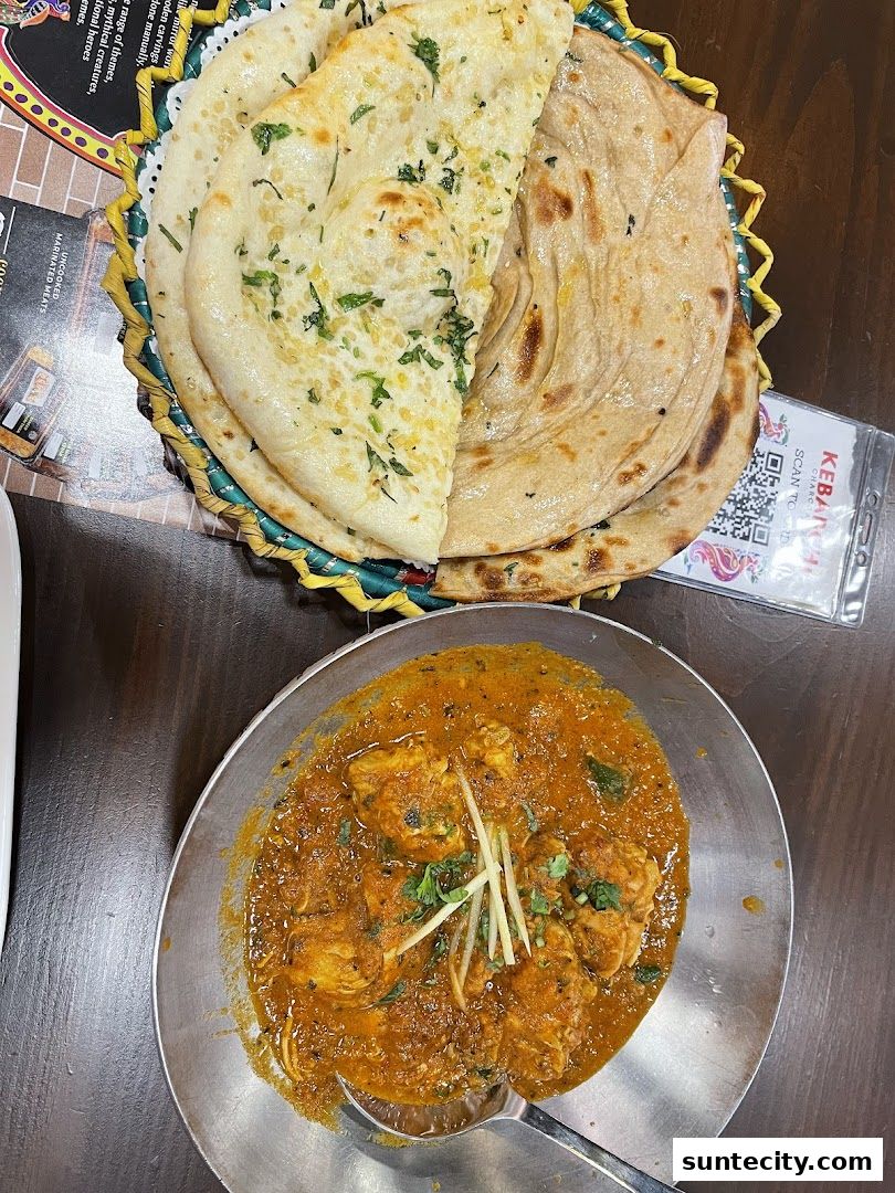 A close-up of a delicious chicken curry dish served with fluffy naan bread.