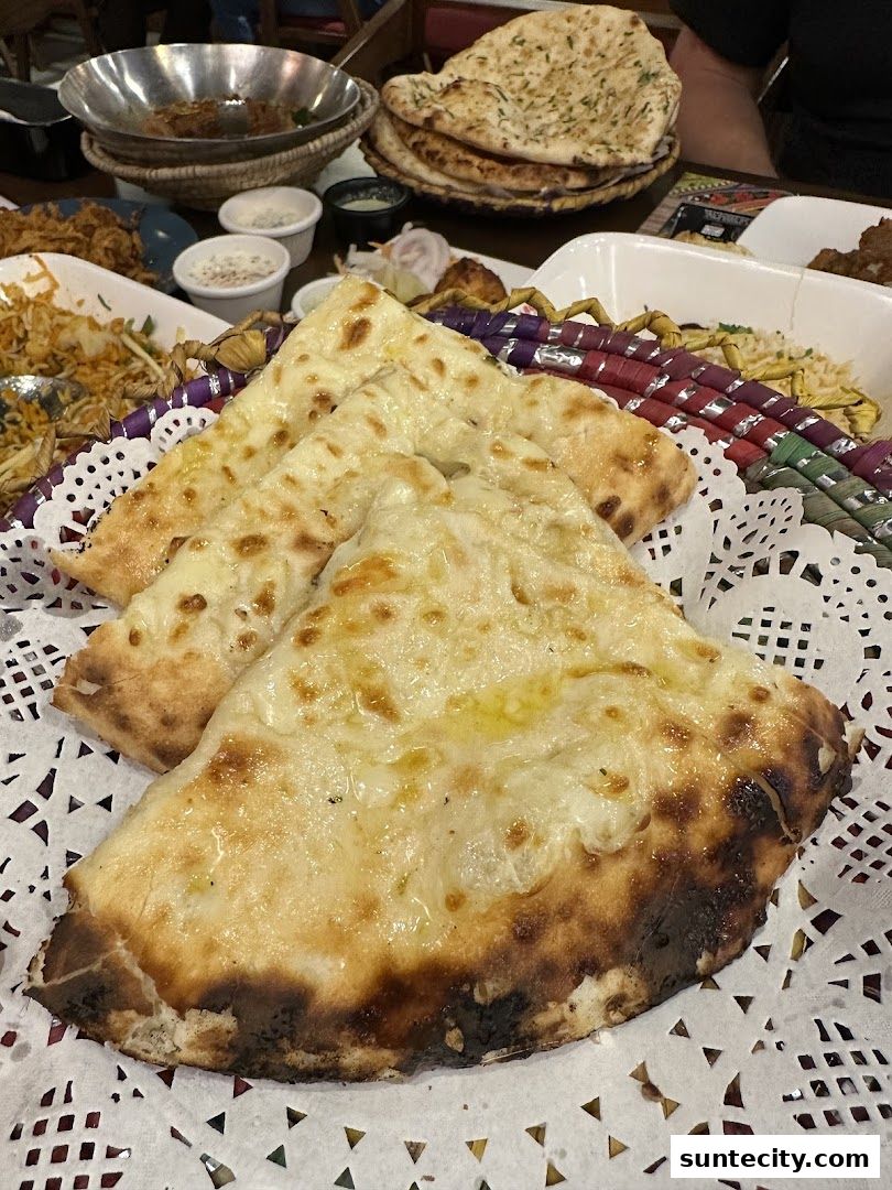 A close-up of delicious naan bread served with various dishes at Kebabchi Charcoal BBQ.