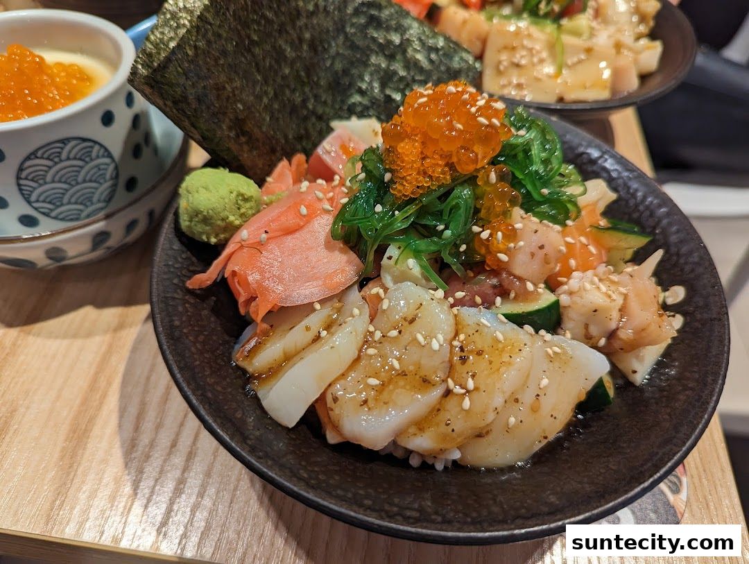 A close-up of a delicious Kaisendon bowl with fresh seafood and a side of chawanmushi.