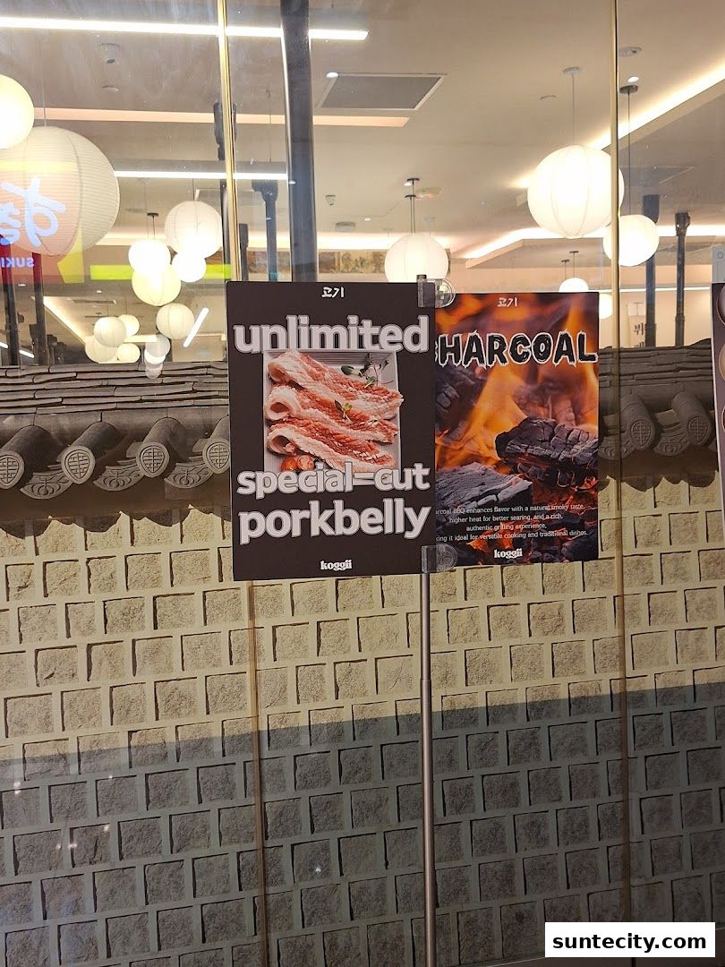 Signs advertising unlimited special-cut porkbelly and charcoal grilling at Koggii.