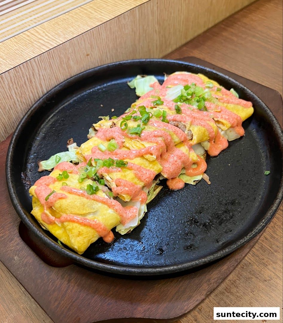 A close-up of a delicious Japanese omelet dish with a creamy sauce and green onions.