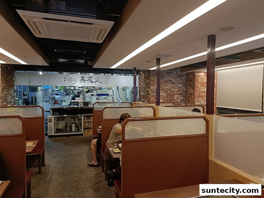 Interior view of Kurohanabi Eat at Seven restaurant with dining booths and an open kitchen.