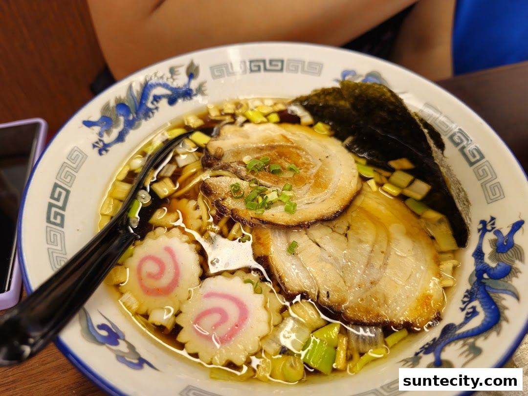 A close-up shot of a delicious bowl of ramen with chashu pork, narutomaki, and nori.