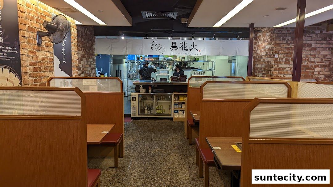 Interior view of Kurohanabi Eat at Seven restaurant with dining booths and kitchen visible.