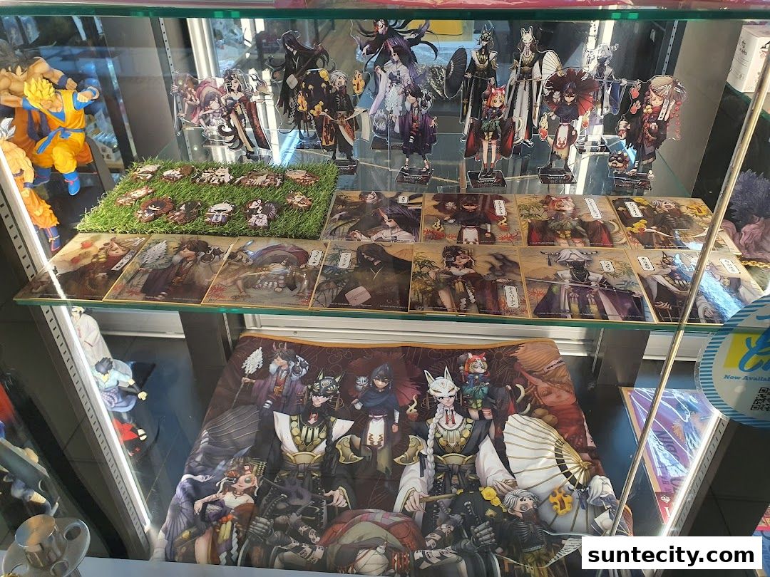 A display case filled with anime figurines, acrylic stands, and collectible cards.
