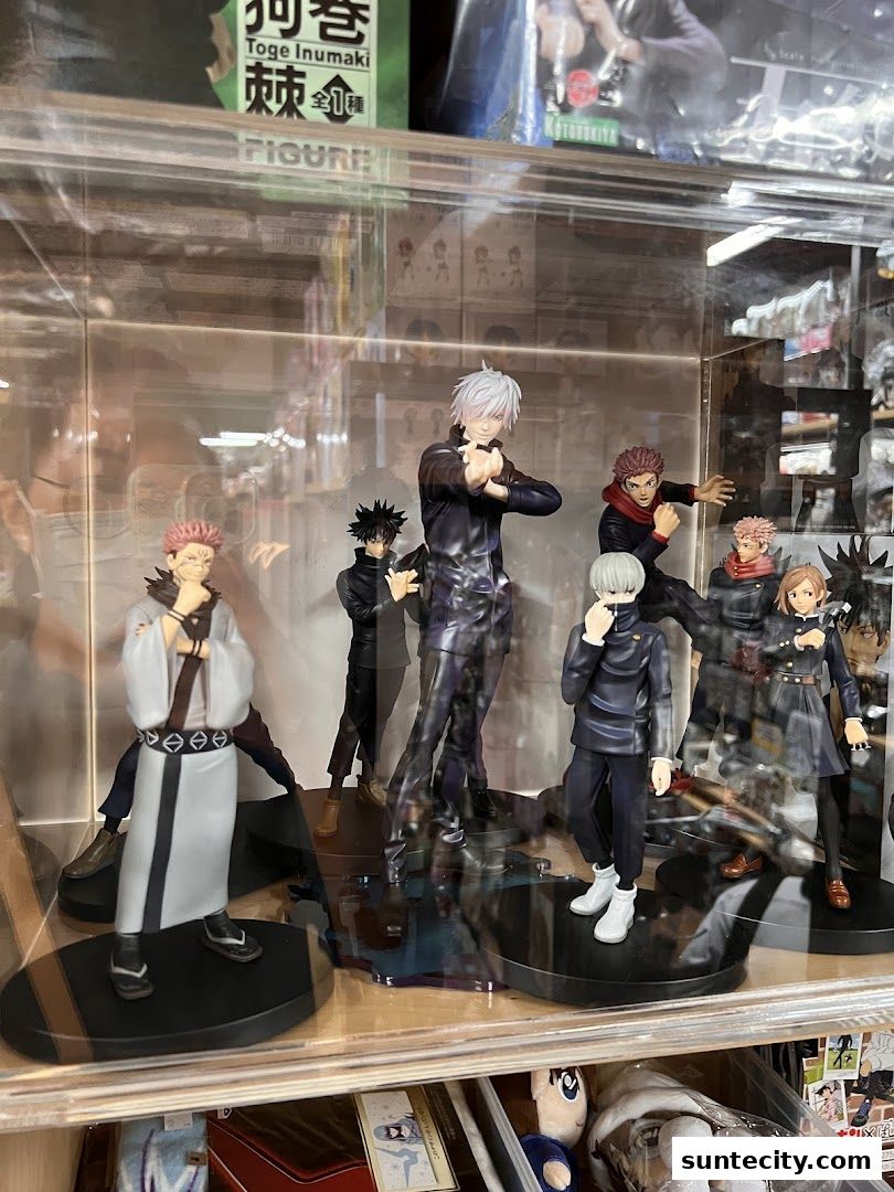 A display case filled with anime character figurines, featuring popular characters from Jujutsu Kaisen.