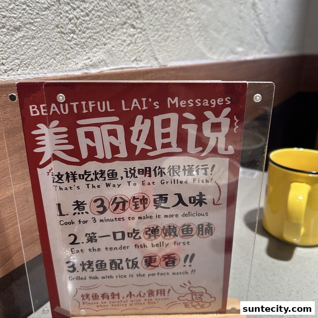 A sign with instructions on how to eat grilled fish, with a yellow mug in the background.