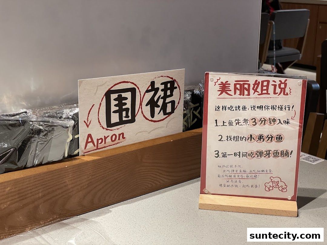 A sign with instructions on how to eat grilled fish, next to aprons.