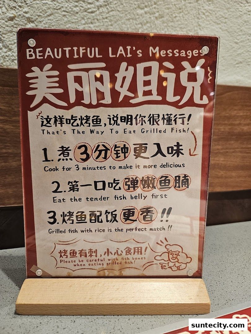 A sign with instructions on how to eat grilled fish, in English and Chinese.