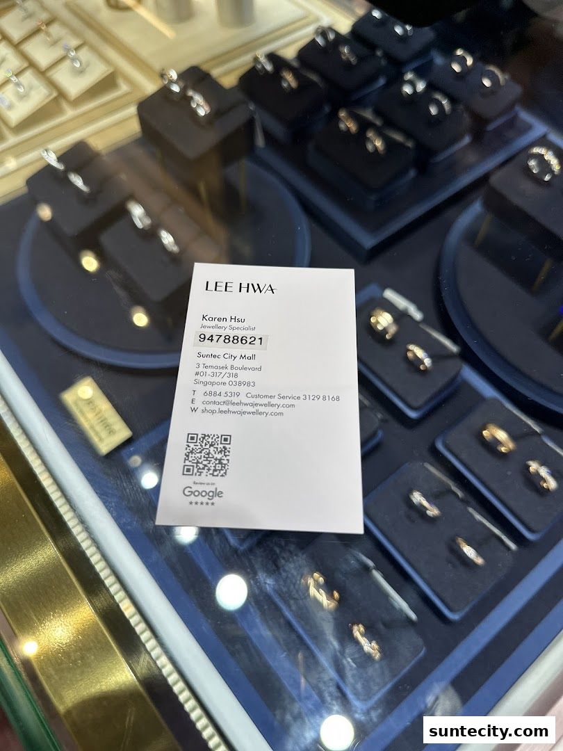 A display case filled with rings and a business card for Lee Hwa Jewellery.