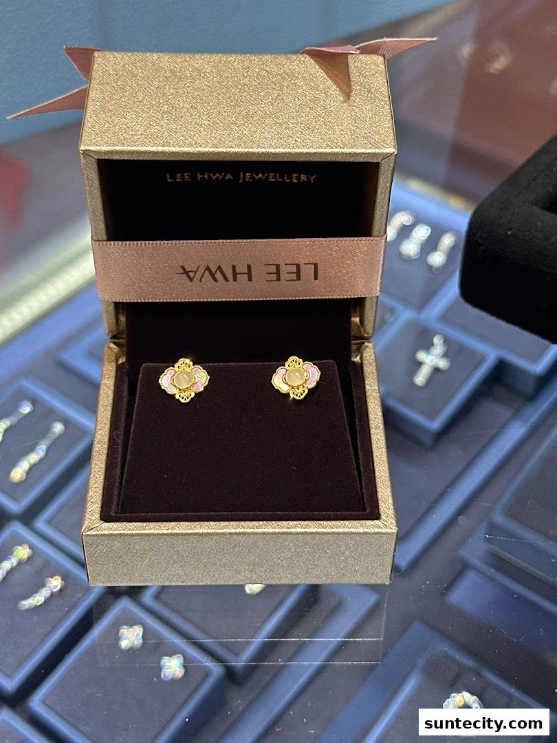 A jewelry box displaying elegant gold earrings with a floral design.