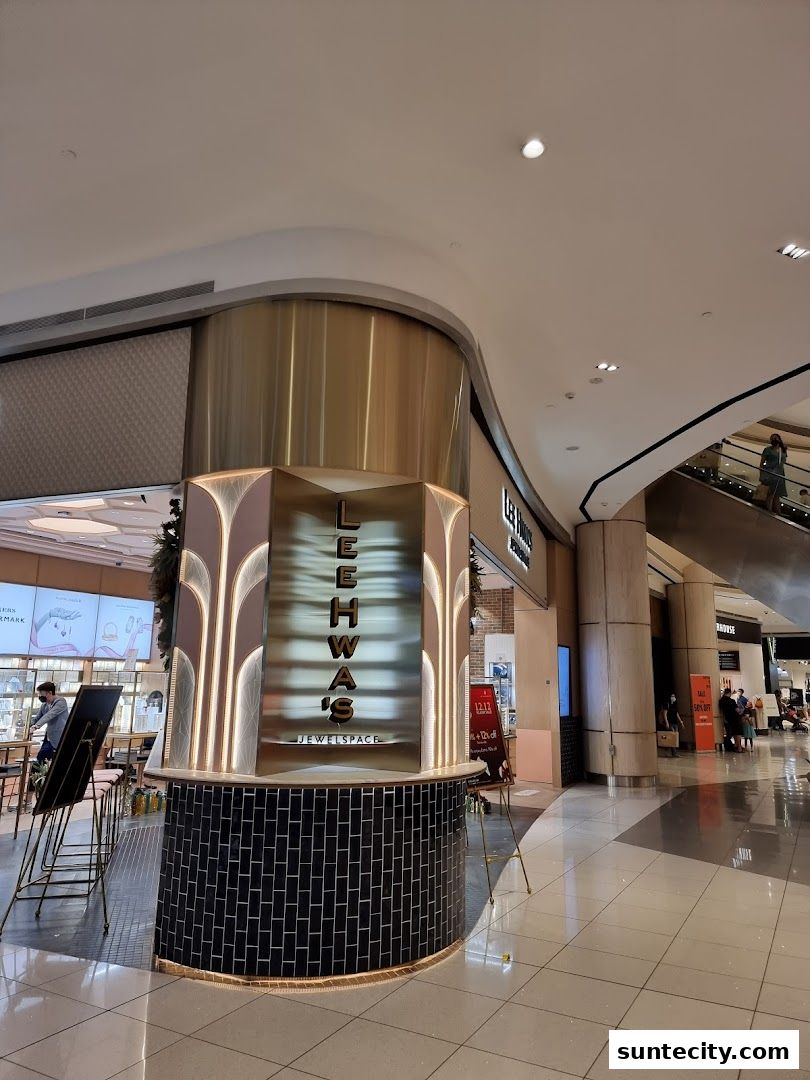The exterior of a modern jewelry store with a distinctive curved facade and illuminated signage.