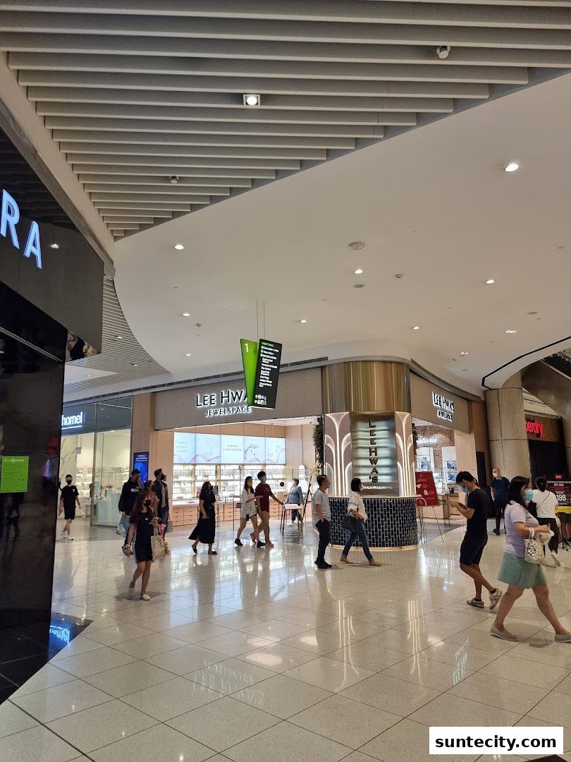 People walking past the Lee Hwa Jewellery store in a modern shopping mall.