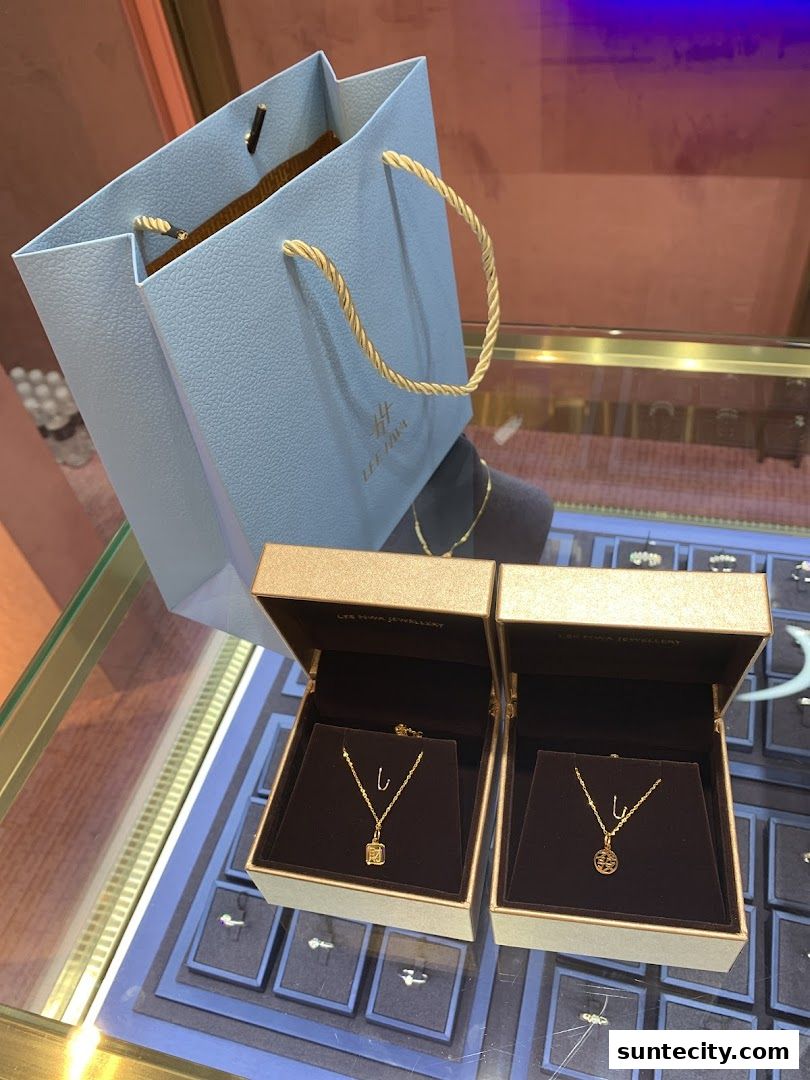 Lee Hwa Jewellery display featuring two necklaces in boxes and a shopping bag.