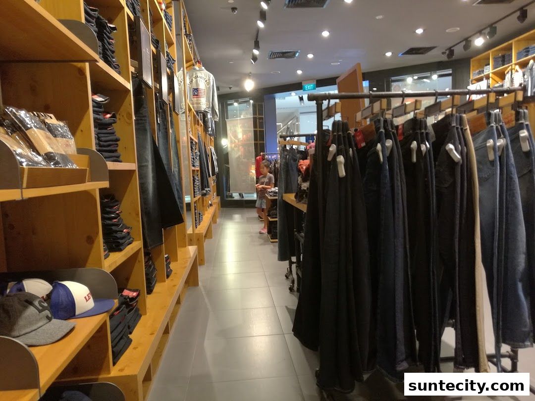 Interior view of a Levi's store showcasing denim jeans, jackets, and caps on display shelves and racks.