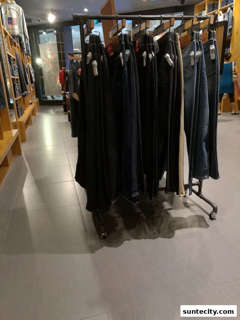 A display of various denim jeans hanging on a rack inside a Levi's store.
