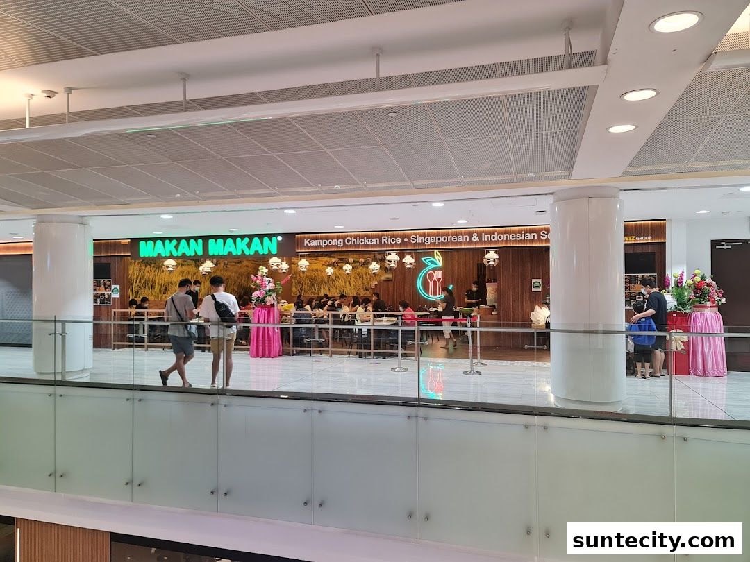 The Makan Makan restaurant features a bright green sign and offers Kampong Chicken Rice, Singaporean & Indonesian cuisine.