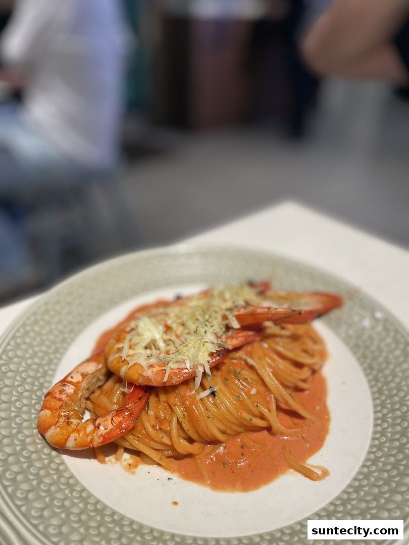 A plate of spaghetti with a creamy tomato sauce, topped with grilled prawns and grated cheese.