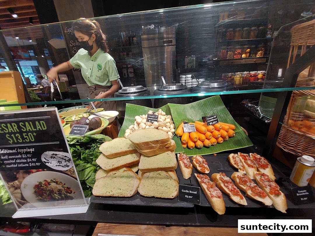 A display of fresh food items including salads, bread, and vegetables at a market stall.