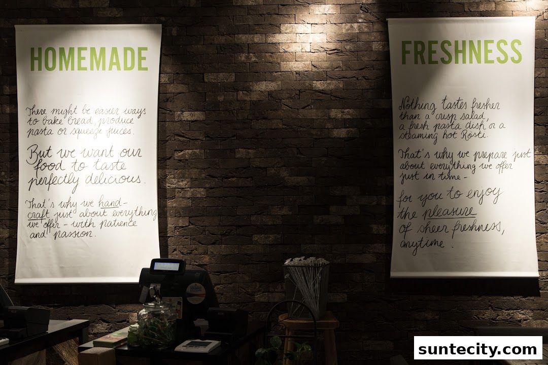 Two posters on a brick wall, one about homemade food and the other about freshness.