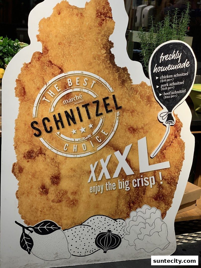 A large cutout of a schnitzel with menu items and prices displayed.