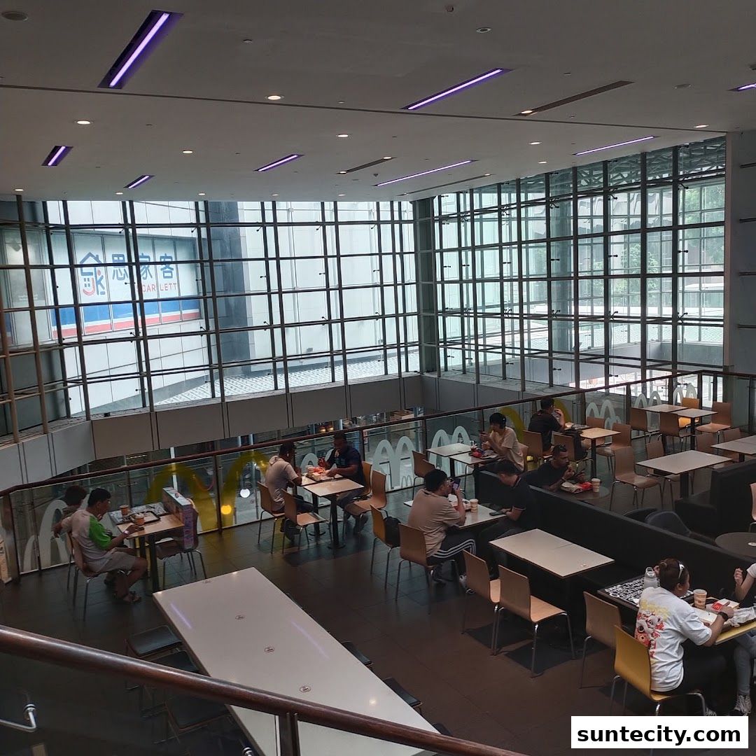 Interior view of a busy McDonald's restaurant with customers dining and large windows.
