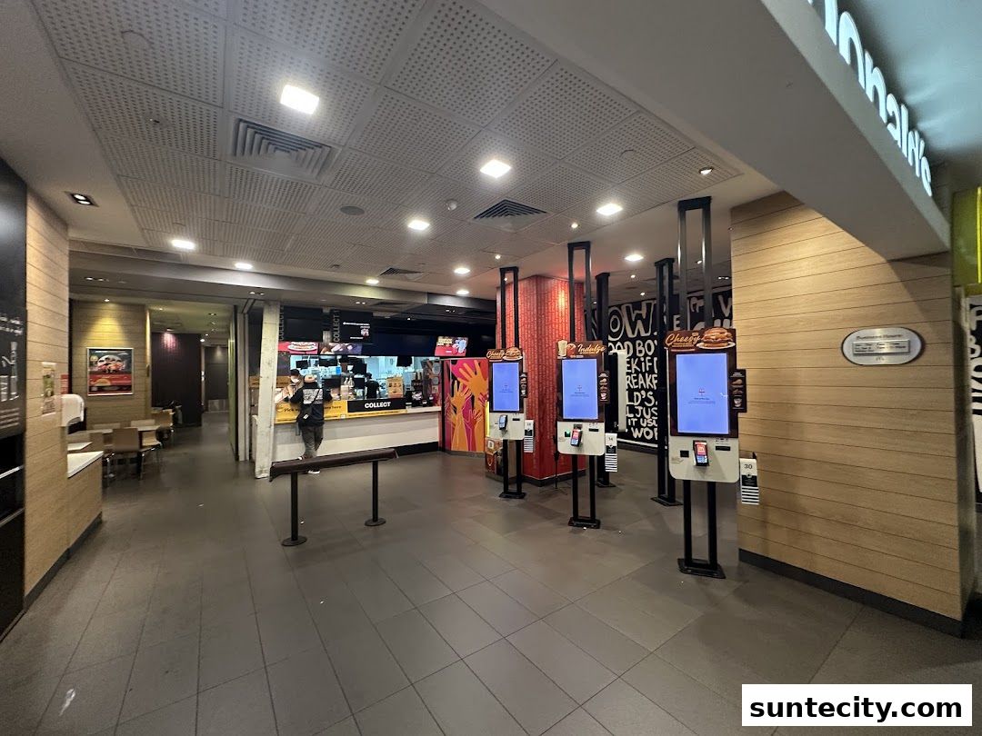 Interior view of a McDonald's restaurant with self-order kiosks and a service counter.