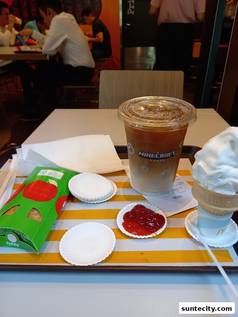 A tray of McDonald's food including a drink, ice cream cone, apple pie, and ketchup.