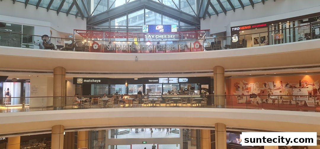 A view of a shopping mall interior with various shops and escalators.