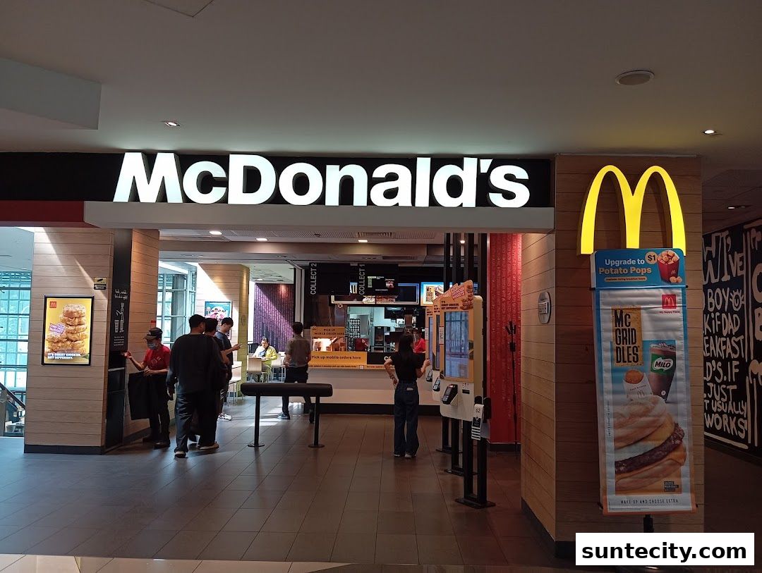 The entrance to a McDonald's restaurant with illuminated signage and promotional displays.