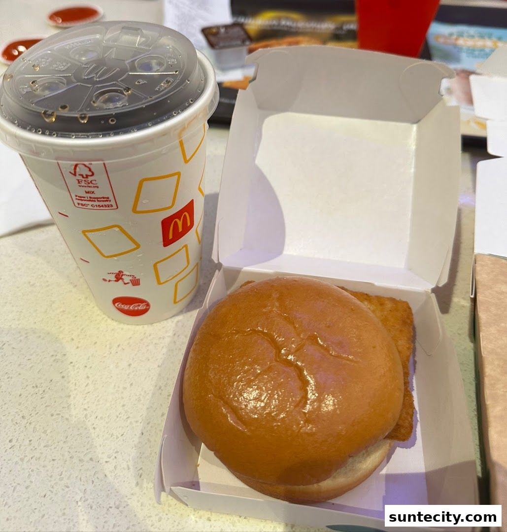 A McDonald's meal featuring a burger in a box and a Coca-Cola drink.