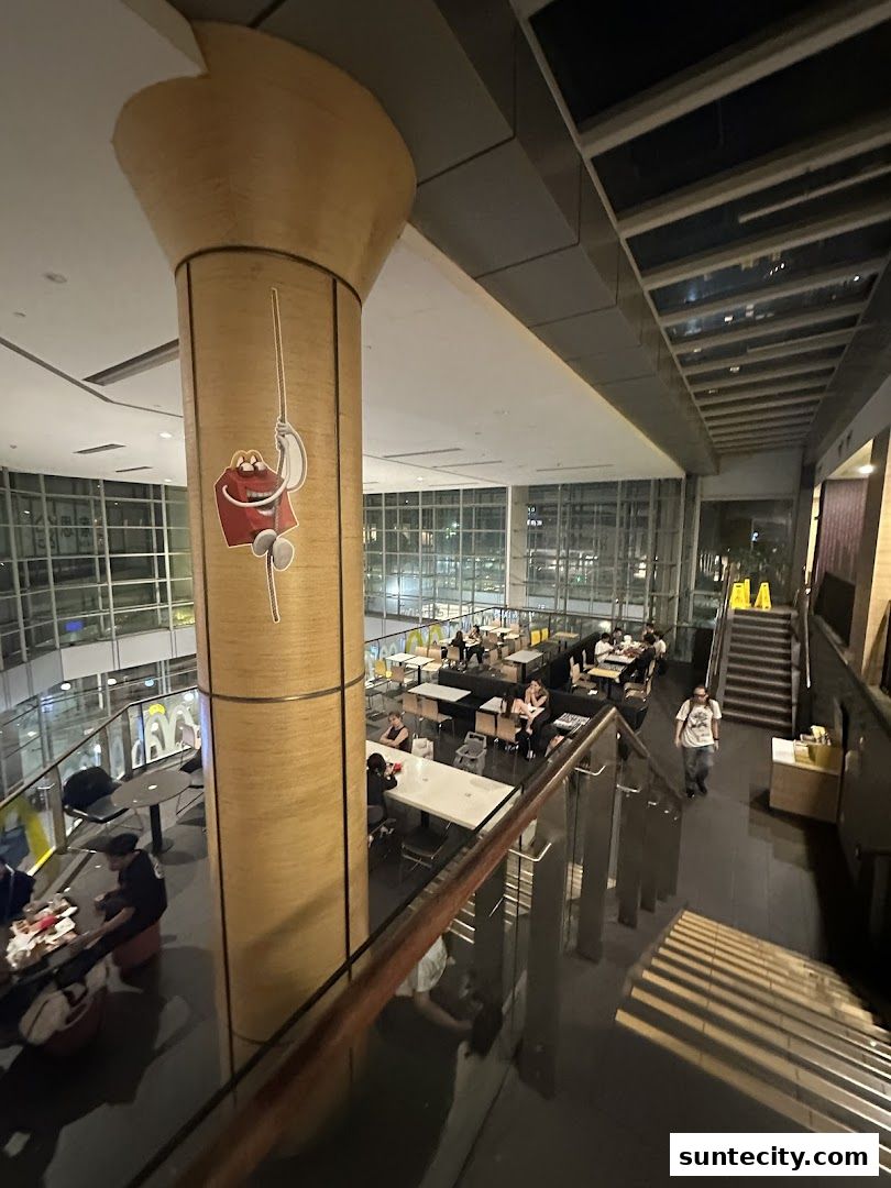 Interior view of a McDonald's restaurant with customers dining and a large pillar with a character.