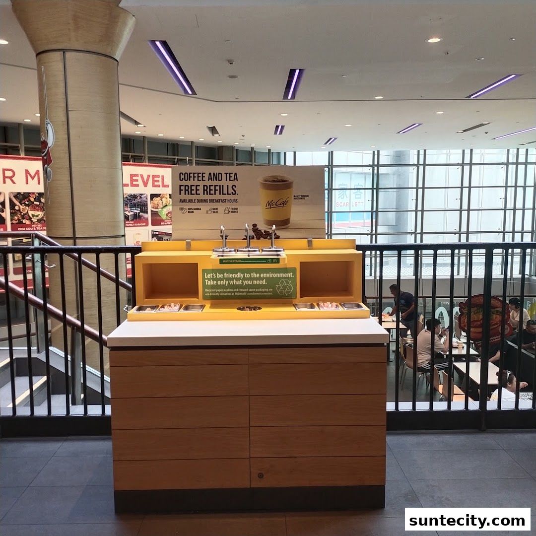 A McCafe self-service station with free coffee and tea refills and recycling bins.