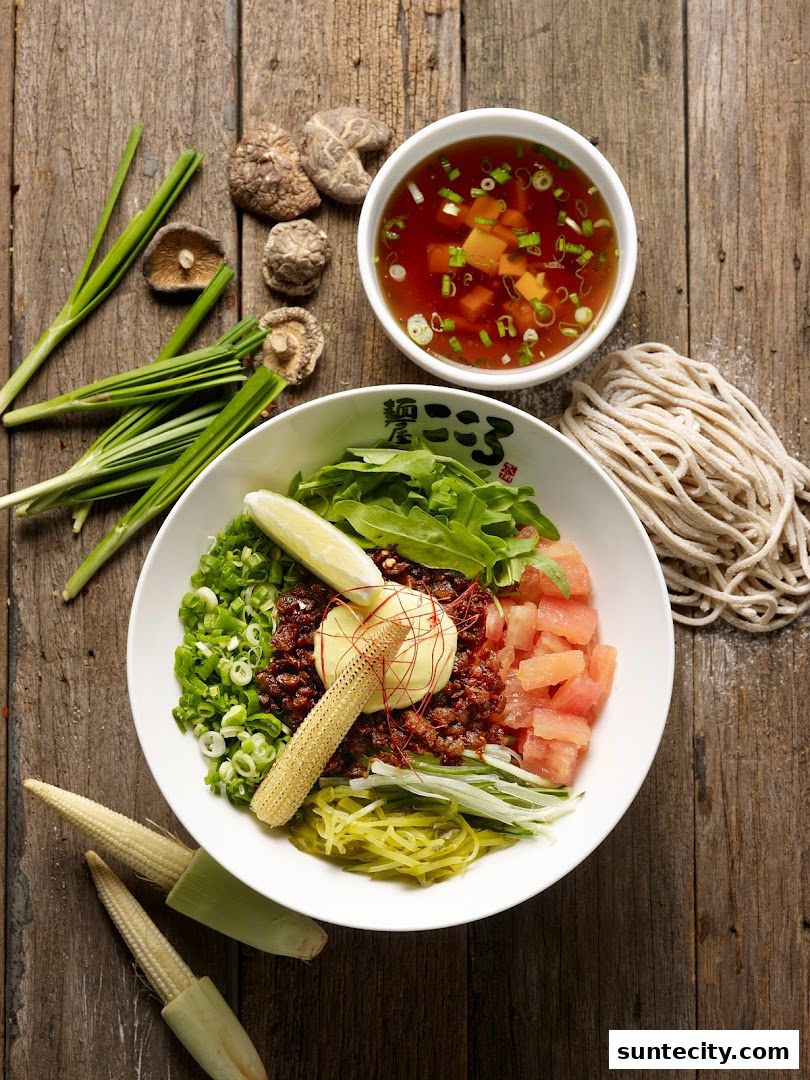 A delicious bowl of ramen with various toppings and a side of broth.
